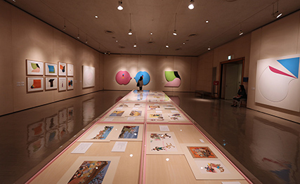 展示風景：中央展示台に藤田桜絵本原画、壁面に高橋秀作品 photo:Nagase Masami